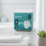 Package of Live Care adult pull-up diapers on a white surface with a plant in the background

