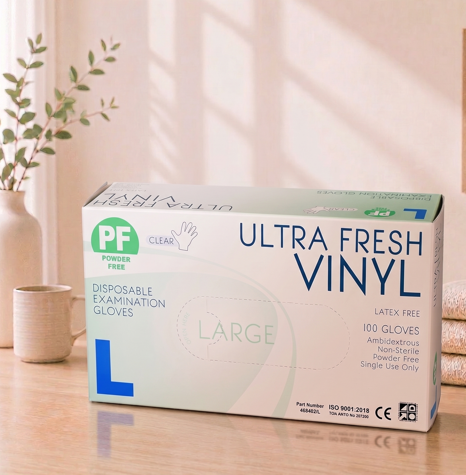 Box of Ultra Fresh Vinyl disposable examination gloves on a wooden surface with a plant in the background

