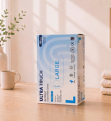 Box of Ultra Touch Nitrile gloves on a wooden surface with a neutral background

