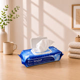 VeraSoft wipes packaging on a wooden surface with a cup and plant in the background

