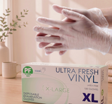 Box of Ultra Fresh Vinyl disposable examination gloves with a hand wearing a glove in the background.

